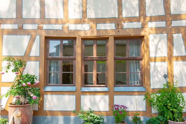 Neues Fenster mit schmalen Ansichtsbreiten umrahmt von zwei historischen Fenstern