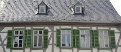 Holzfenster mit Sprossen in Fachwerkhaus mit grünen Fensterläden