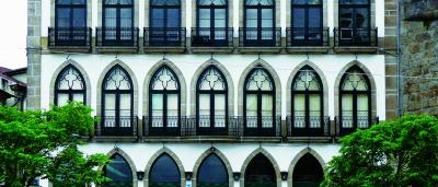 portugiesisches Haus mit spitzbogigen Fenstergewaenden und maßwerkartig gestalteten Oberlichtteil