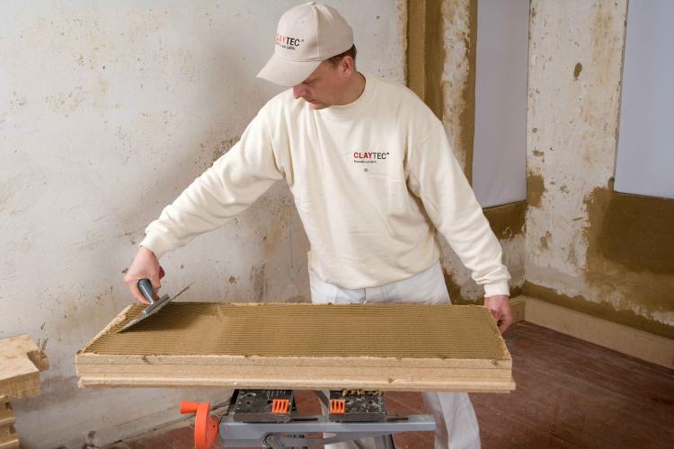Holzfaserdämmplatten werden mit Lehmmörtel an der Innenwand befestigt