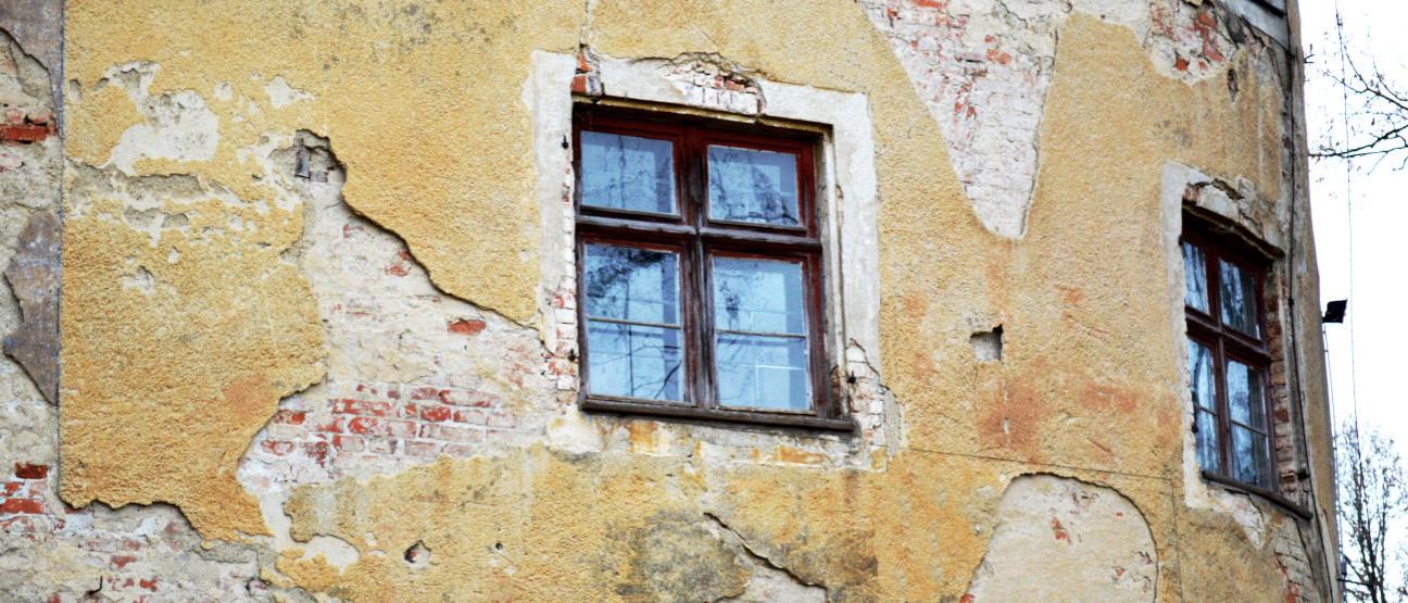 Historisches Fenster in einer beschädigten Fassade