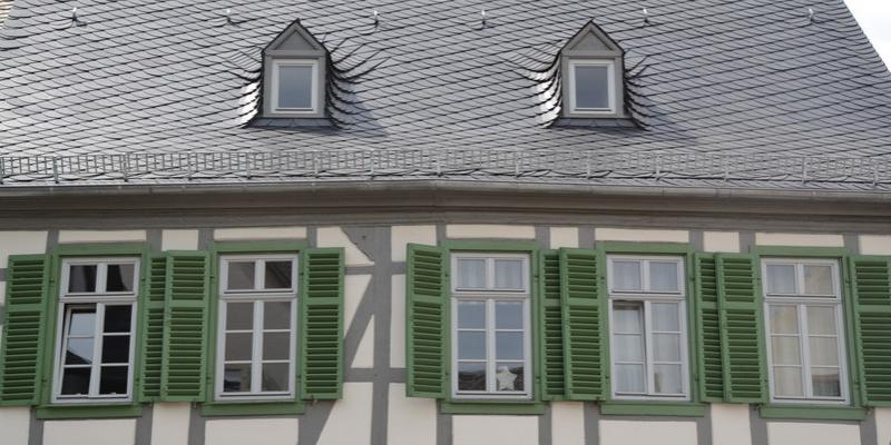 Holzfenster mit Sprossen in Fachwerkhaus mit grünen Fensterläden