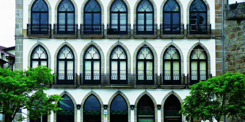 portugiesisches Haus mit spitzbogigen Fenstergewaenden und maßwerkartig gestalteten Oberlichtteil